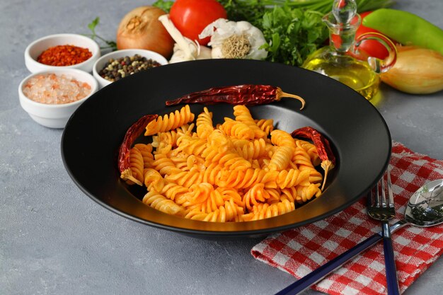 Photo pasta fusilli dans de la sauce tomate fond gris concept alimentaire italien