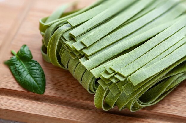 Pasta italienne de tagliatelle faite maison à base d'épinards verts crus en gros plan