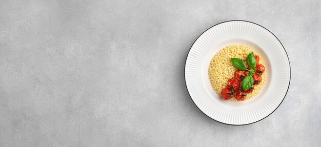 Pasta ptitim couscous israélien dans une assiette blanche vue supérieure espace de copie