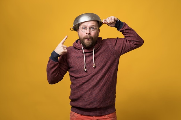 Pastafarisme. Un homme mignon met une passoire sur la tête et la pointe du doigt