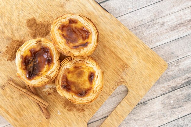 Pastel de nata ou pastel de belem du PortugalxTrois desserts sur la planche à couper en bois