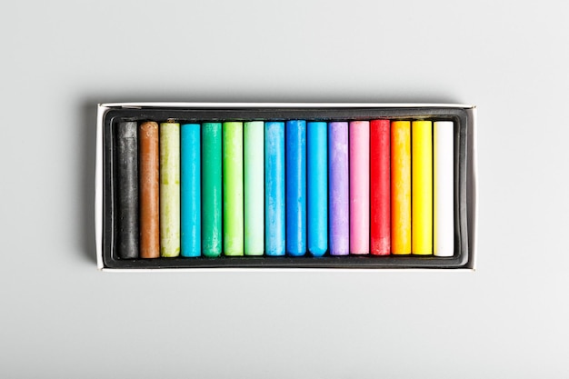 Pastels de crayons multicolores sur fond gris dessin et concept de passe-temps pour enfants minimalisme vue de dessus