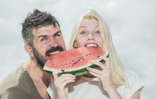 La pastèque comme symbole de l'unité et de l'unité de l'été Portrait d'un couple heureux appréciant la pastèque pendant les vacances d'été s'amusant ensemble