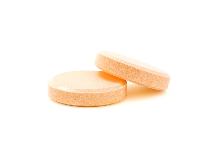 Pastilles vitaminées rondes ou comprimés de suppléments isolés sur fond blanc avec un tracé de détourage