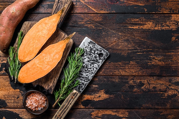 Patate douce coupée crue sur une planche à découper en bois