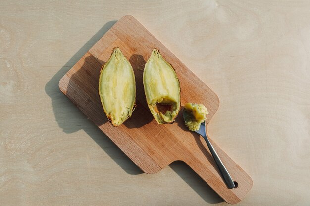 Patate Douce Coupée En Deux Avec Une Cuillère à Café Sur Planche De Bois