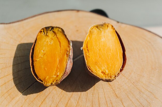 Patate douce coupée en deux sur plaque de bois