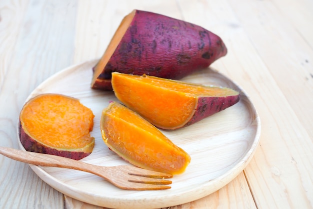 Patate douce cuite à la vapeur dans un plat en bois sur une table en bois