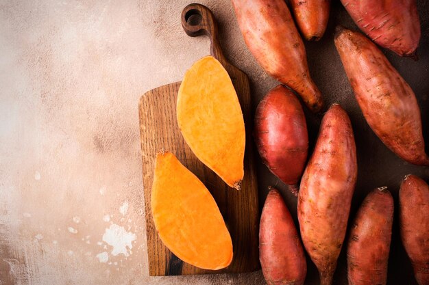 Patate douce sur fond marron Nourriture exotique Une récolte de légumes frais Patate douce crue