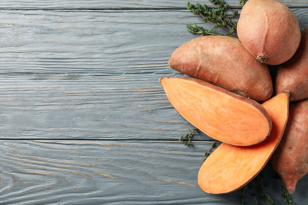 Patates douces et thym sur une surface en bois