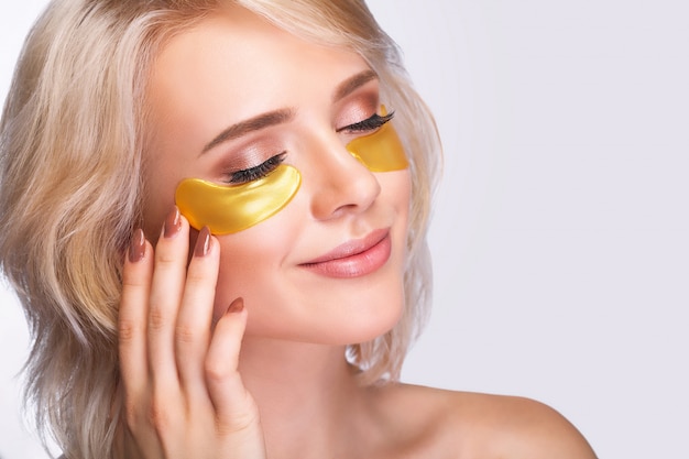 Patch sous les yeux. Beau visage de femme avec des correctifs d&#39;hydrogel d&#39;or