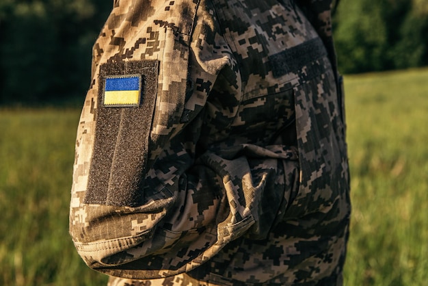 Patch velcro en gros plan avec le drapeau de l'Ukraine sur le bras des soldats en uniforme militaire