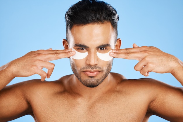 Photo patchs pour les yeux de l'homme et beauté pour les cosmétiques de soin de la peau ou les produits pour le visage sur fond de studio bleu