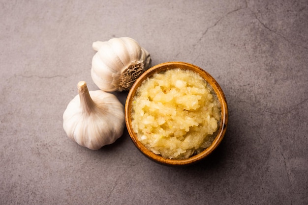 Pâte d'ail ou purée de Lahsun avec des matières premières entières, isolées sur fond blanc. Mise au point sélective