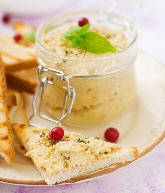 Pâté au poulet, pain grillé et herbes sur une assiette