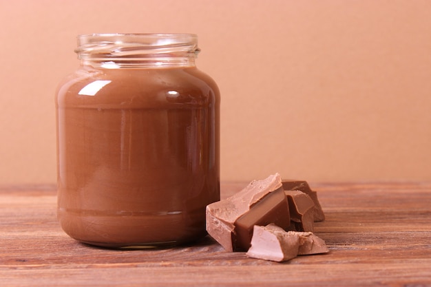 Pâte de chocolat dans un bocal en verre sur fond coloré