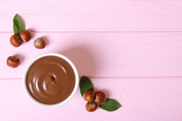 Pâte de chocolat dans un bocal en verre sur fond coloré