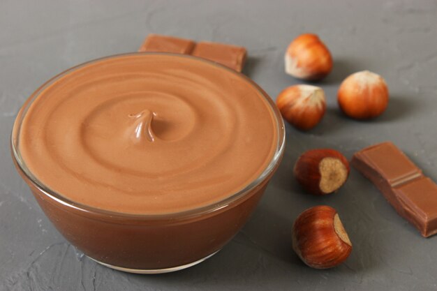 Pâte de chocolat dans un bocal en verre sur fond coloré