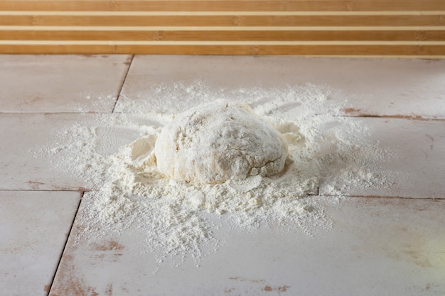 La pâte est saupoudrée de farine et repose sur la table. Le processus de cuisson des biscuits à la maison