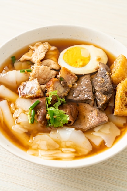 pâte de farine de riz ou carré de pâtes chinoises bouillies avec du porc dans une soupe brune - style de cuisine asiatique