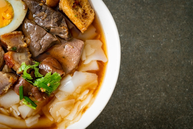 pâte de farine de riz ou carré de pâtes chinoises bouillies avec du porc dans une soupe brune - style de cuisine asiatique