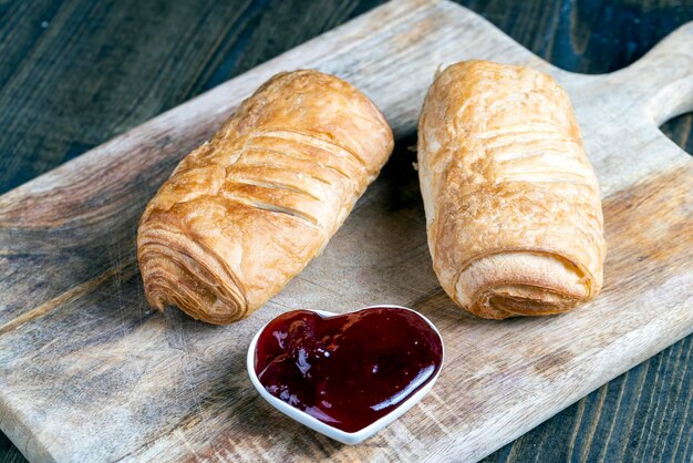 Pâte feuilletée à la confiture de fraise rouge sur une table en bois