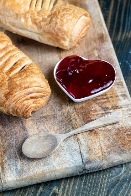 Pâte feuilletée à la confiture de fraise rouge sur une table en bois