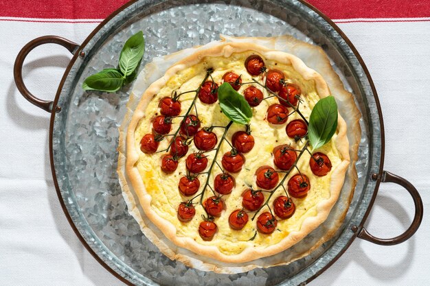 Pâte feuilletée italienne d'été avec tomates cerises et ricotta sur une nappe blanche