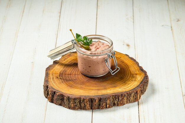 Pâté de foie de poulet dans un bocal en verre planche de bois