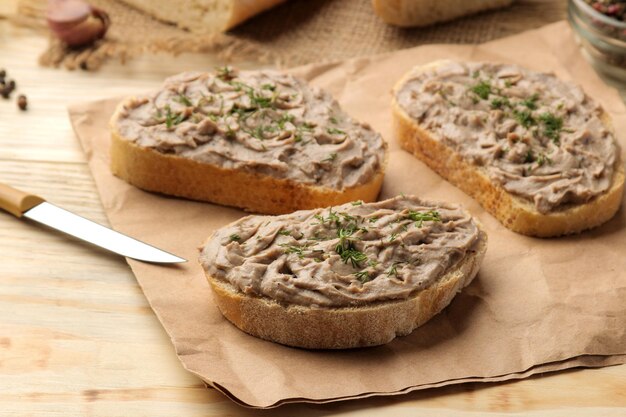 Pâté de foie de poulet frais fait maison avec des herbes pour le pain sur une table en bois naturel. Un sandwich.