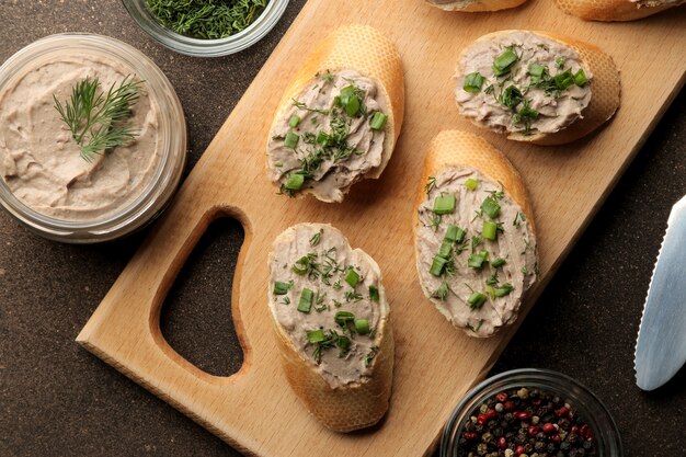 Pâté de foie de poulet frais fait maison avec des verts sur du pain sur un fond sombre. vue d'en-haut