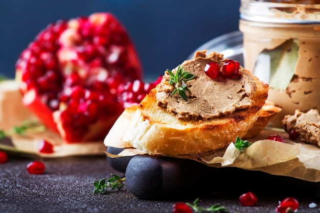 Pâté de foie de viande sur du pain grillé avec des graines de fruits et des herbes d'épices table de cuisine brune copie espace mise au point sélective