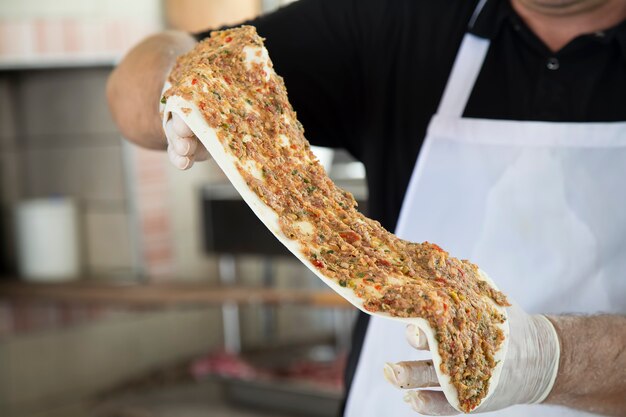 Pâte avec des ingrédients pour la pizza