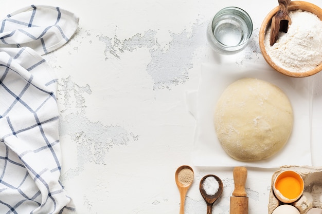 Pâte et ingrédients pour la préparation de pâtes, pâte, œufs, farine, eau et sel sur une vieille table rustique légère