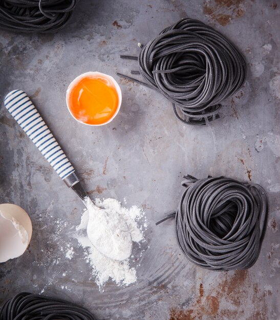 Pâte noire brute et les ingrédients sont faits maison, cuisine italienne spaghetti