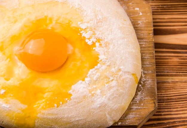 Pâte non cuite à l'oeuf sur une table en bois