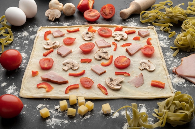 Photo pâte à pizza à angle élevé avec des légumes