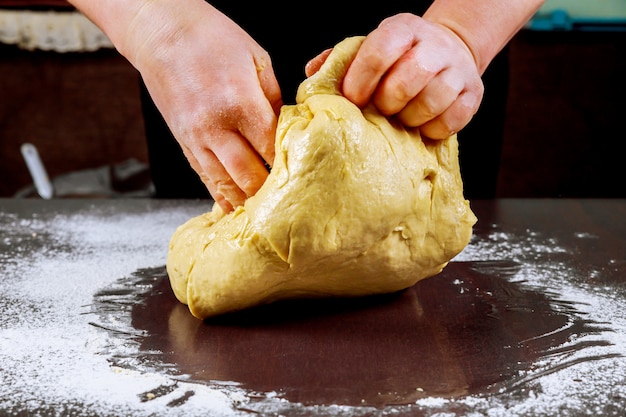 Pâte à pizza crue entre les mains du chef