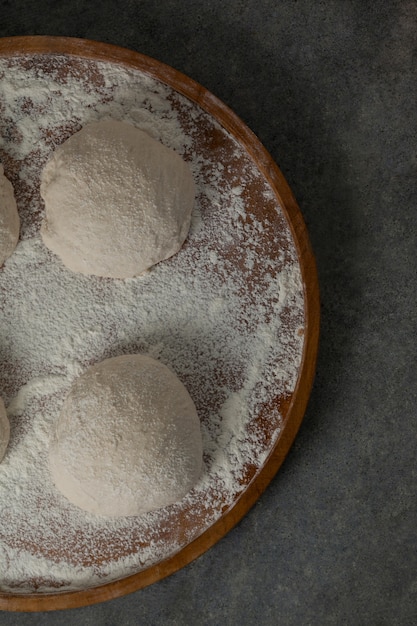 Pâte à pizza et farine sur planche à rouler