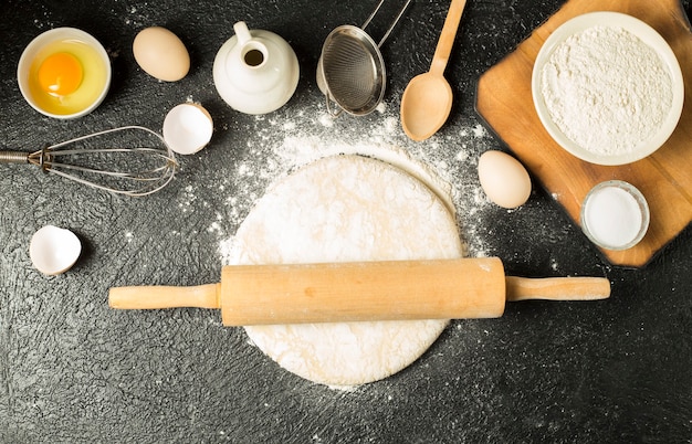 Photo pâte à plat pour pizza sur fond noir