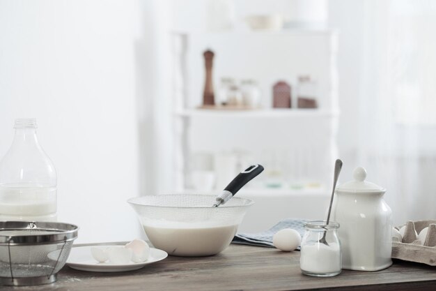 Pâte sur table en bois dans une cuisine blanche