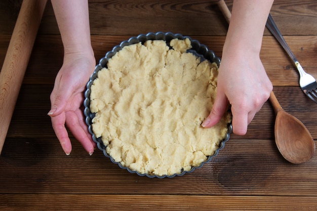 Pâte à tarte crue, base pâtissière pour tarte, tarte ou gâteau. Cuisson dessert sain dans le plat de cuisson.