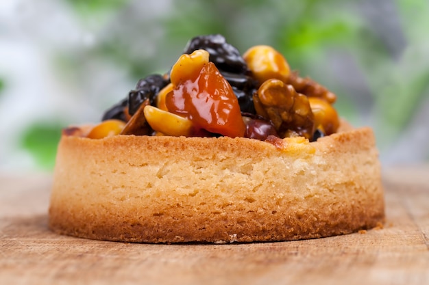 Pâte à tartelette aux noix et fruits secs recouverte de caramel, petite tartelette ronde aux garnitures variées, tartelette croustillante aux noisettes, cacahuètes et autres ingrédients