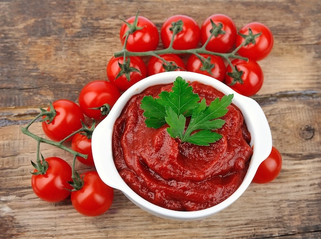 Pâte de tomates aux tomates mûres sur des tables en bois