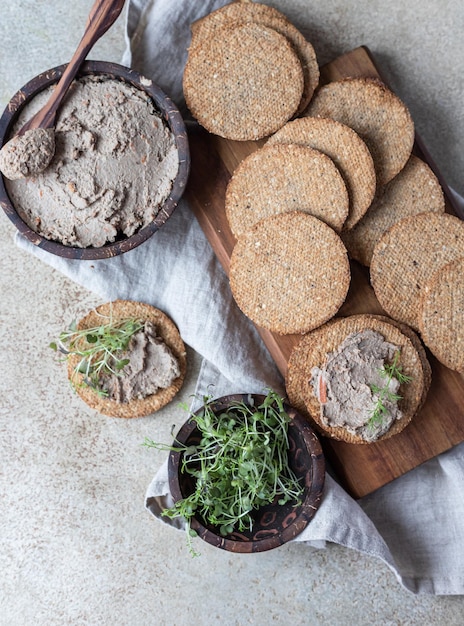 Photo pâté de viande ou de foie de poulet fait maison avec craquelins multigrains et microgreen