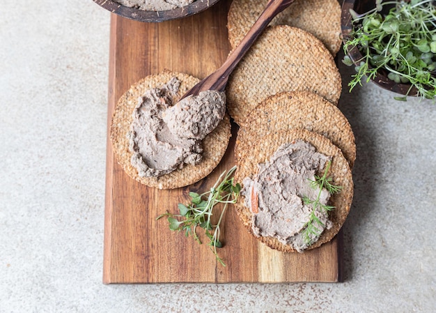 Pâté de viande ou de foie de poulet fait maison avec craquelins multigrains et microgreen