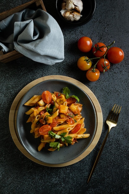 Pâtes alla norma aux herbes tomates aubergines à la sauce tomate sur fond sombre vue de dessus