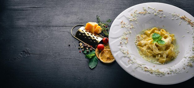 Pâtes au fromage sur une assiette avec le mot "coller". Vue de dessus. Espace libre pour le texte. Sur un fond en bois.