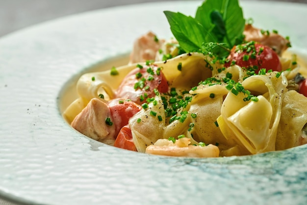 Pâtes au saumon et légumes dans une assiette. Mise au point sélective, gros plan