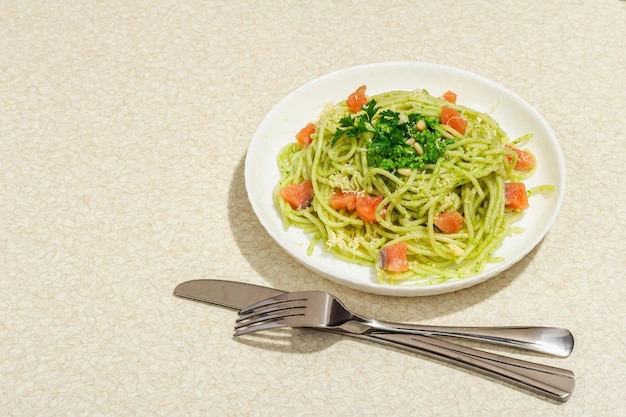 Pâtes au saumon, pesto de poireaux sauvages et parmesan Spaghettis frais et légumes verts Nourriture végétalienne saine